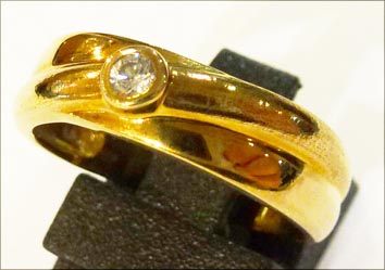Exklusives Design. Ring 17,5 mm aus feinem Gelbgold 333/-, verziert  mit 1 funkelnden Zirkonia. Der Ring ist hochglanzpoliert und hat zwei ineinander verlaufende Ringschienen was ihn zu einem wahren Eyecatcher macht. Ein Unikat aus unserem Hause für alle,